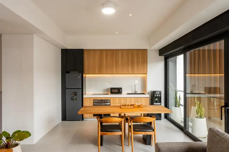 Une cuisine moderne avec une table à manger en bois et des tabourets.