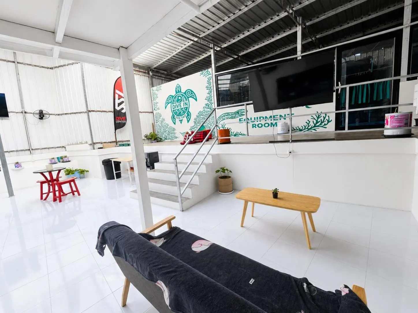 Espace de détente extérieur avec canapé et mobilier en bois.