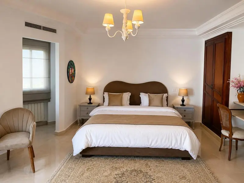 Chambre lumineuse avec un grand lit et un mobilier en bois.