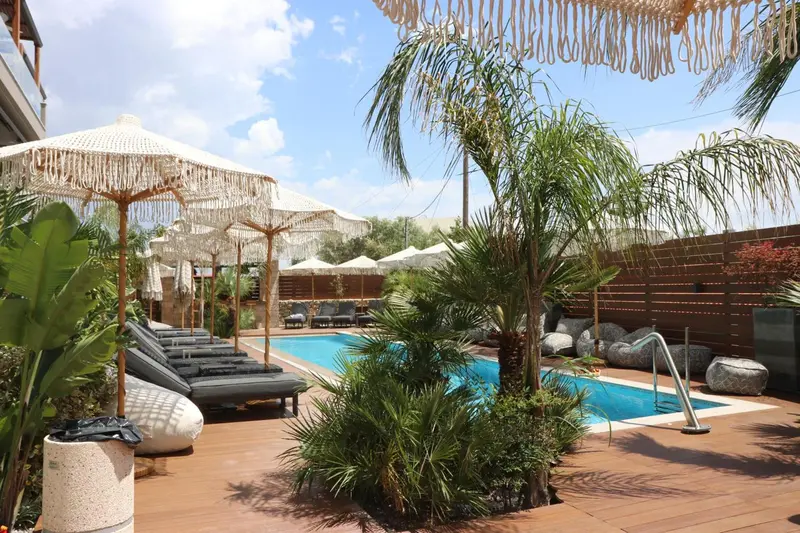Transats et parasols ombragent une piscine rectangulaire entourée de végétation luxuriante.