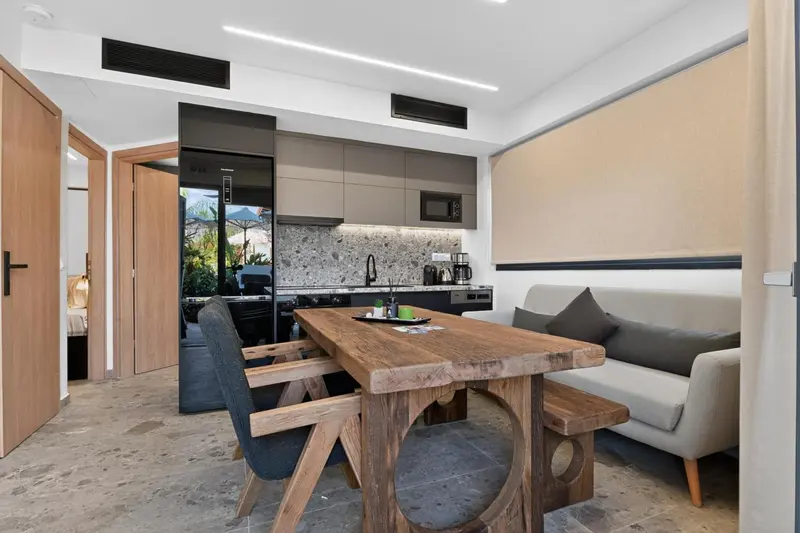 Une salle à manger lumineuse s'ouvre sur une cuisine moderne.