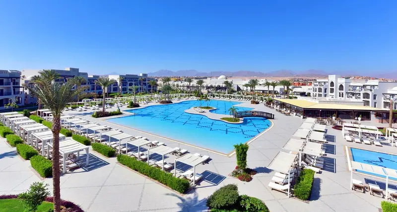 Vue aérienne d'un complexe hôtelier avec piscine et transats.
