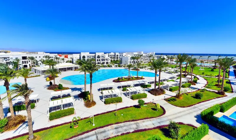 Vue aérienne d'un complexe hôtelier avec piscine et végétation luxuriante.