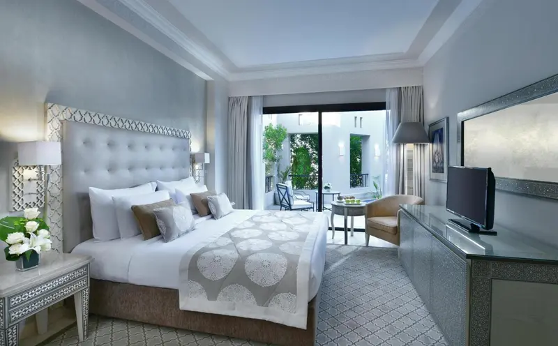 Une chambre lumineuse avec un grand lit et un accès à une terrasse.