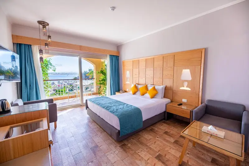 Une chambre lumineuse avec un grand lit et un accès à un balcon.