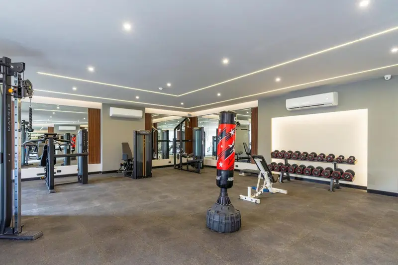 Une salle de sport lumineuse avec des équipements de musculation et de cardio.