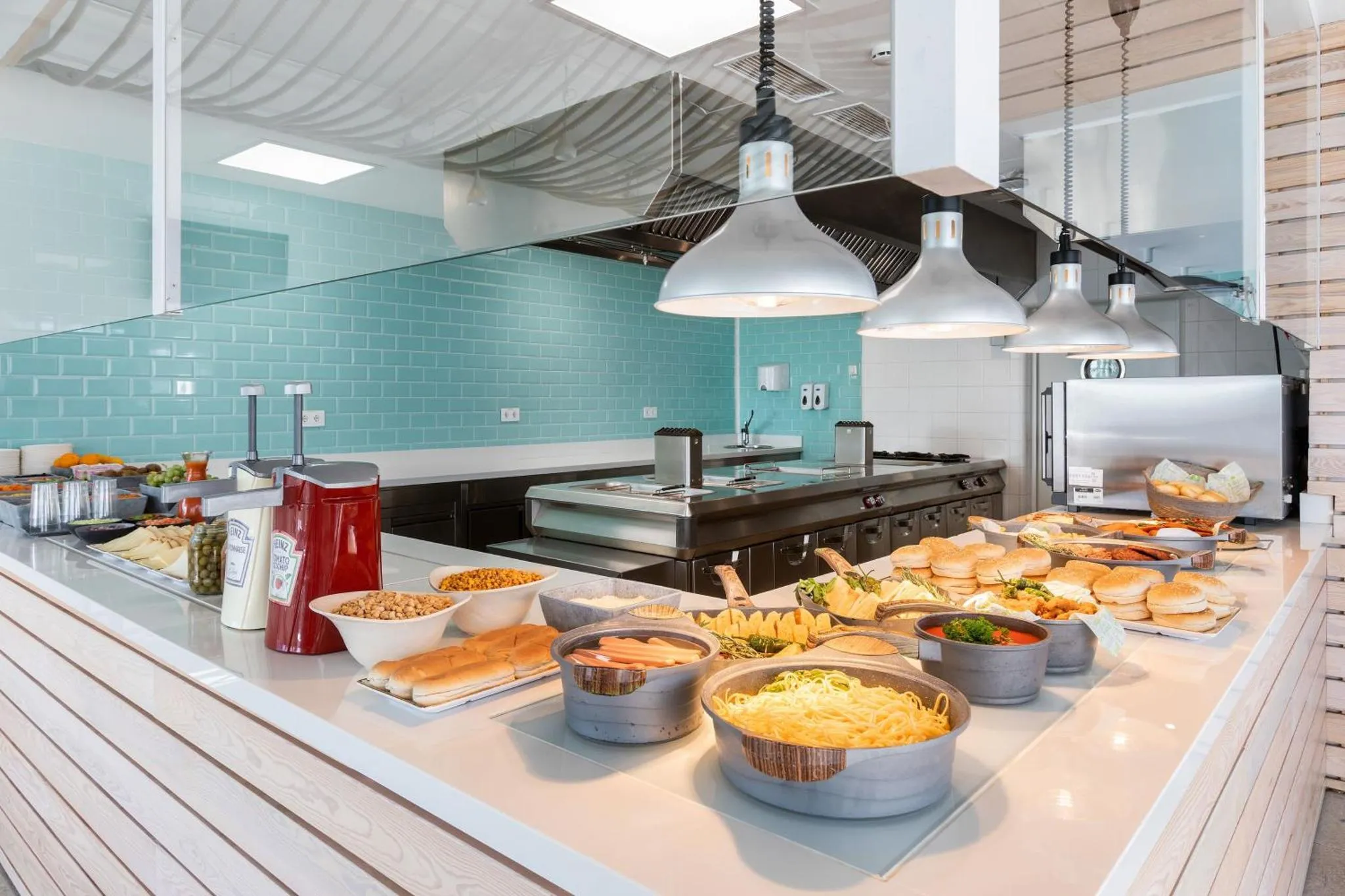 Un buffet propose une variété de plats et de salades dans un espace lumineux.
