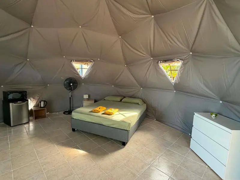 Une chambre lumineuse avec un lit recouvert de coussins et de serviettes.