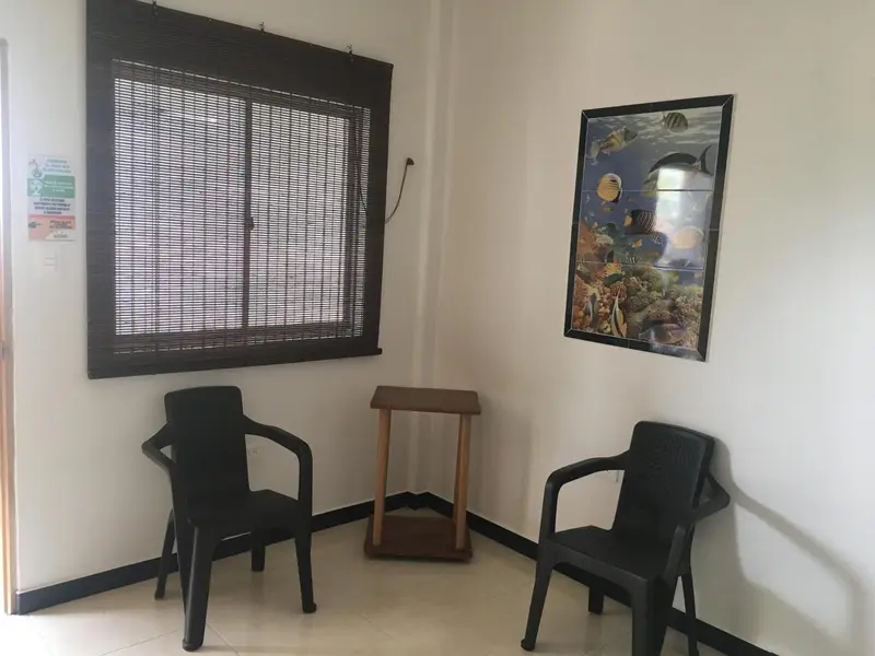 Une salle d'attente avec deux chaises et un tableau décoratif.