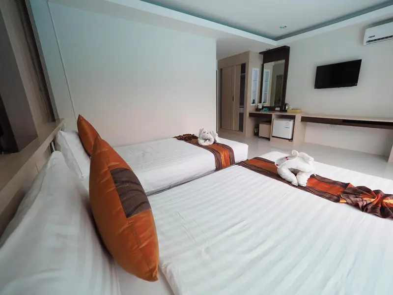 Chambre lumineuse avec deux lits simples et une décoration soignée.