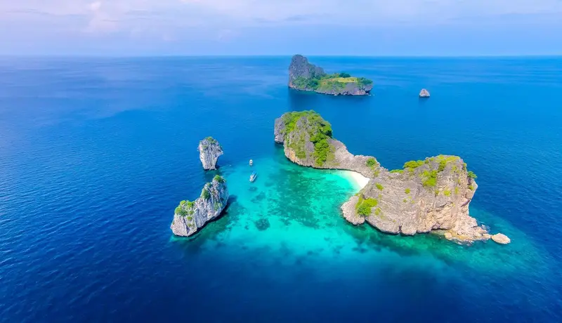 Vue aérienne d'îlots rocheux entourés d'une mer turquoise.