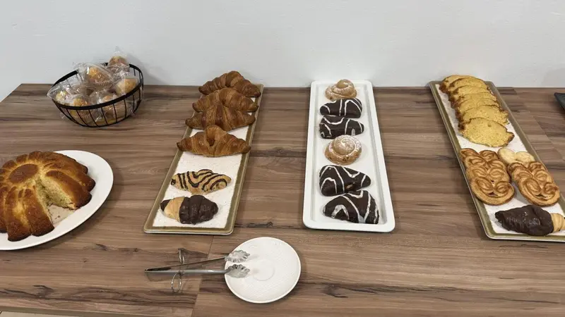 Une variété de viennoiseries et de pâtisseries sont présentées sur un comptoir.