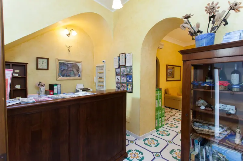 Un comptoir d'accueil en bois dans un hall lumineux avec des décorations murales.