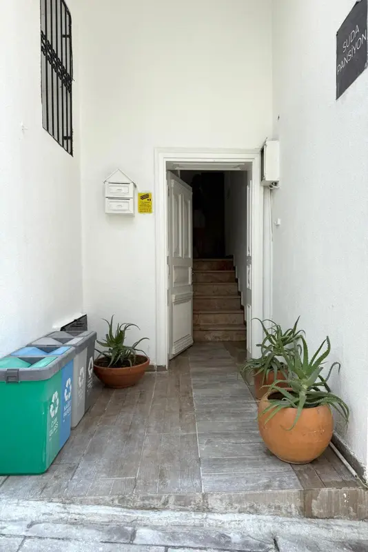 Un couloir d'accès mène à un escalier en pierre.