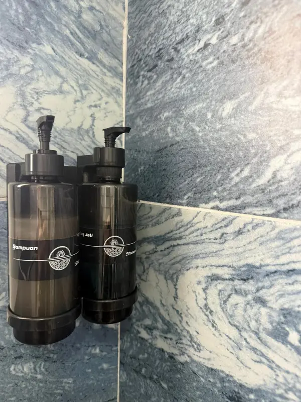 Deux distributeurs de savon muraux dans une salle de bain.