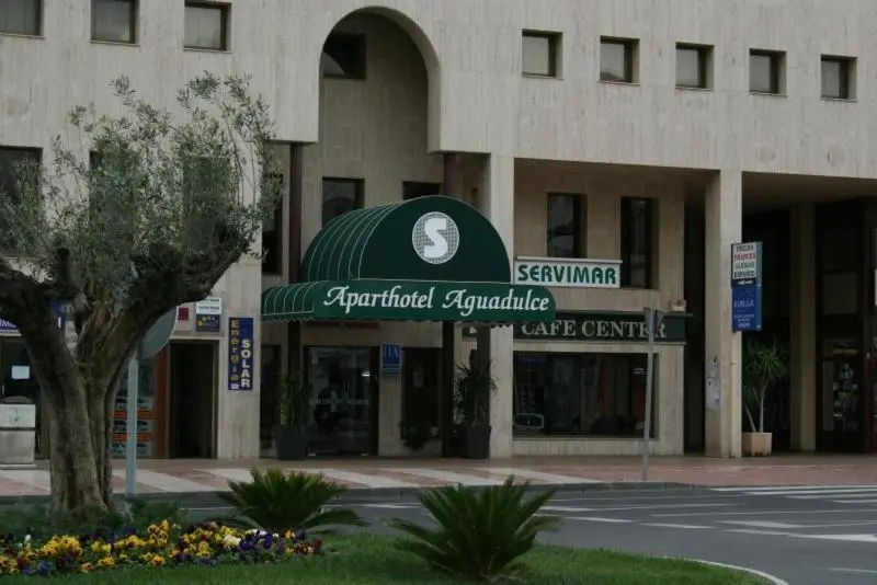 Façade d'un bâtiment avec un auvent vert et des commerces en rez-de-chaussée.