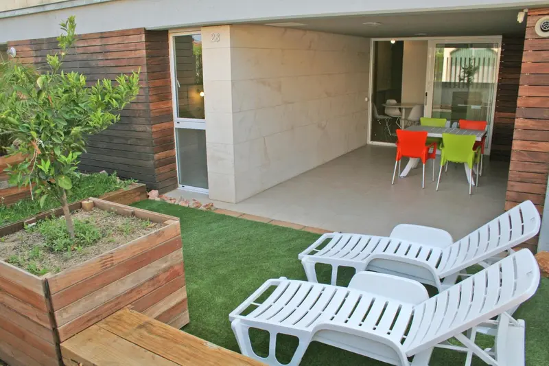 Terrasse avec mobilier de jardin et table à manger.