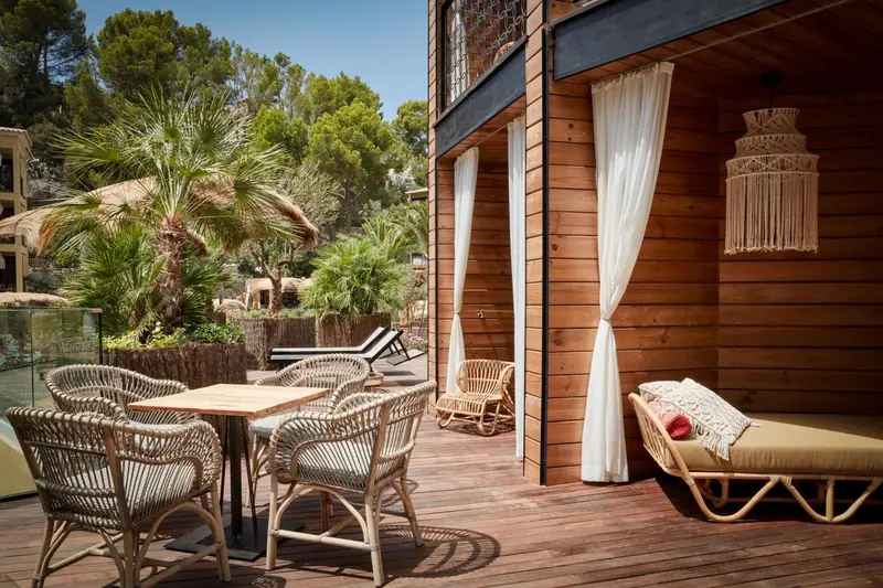 Terrasse en bois avec mobilier d'extérieur et végétation luxuriante.