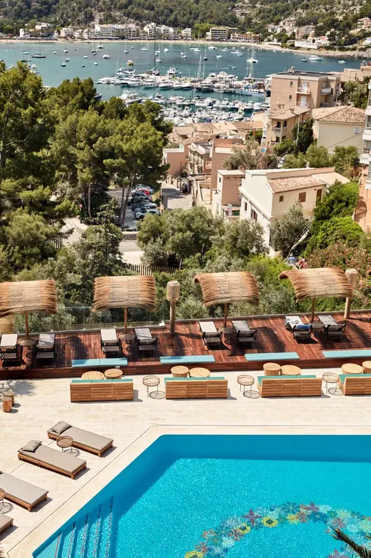 Terrasse avec transats et piscine donnant sur une baie.