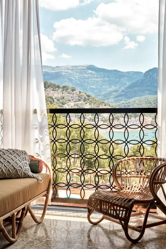 Vue sur un paysage montagneux et la mer depuis une terrasse aménagée.