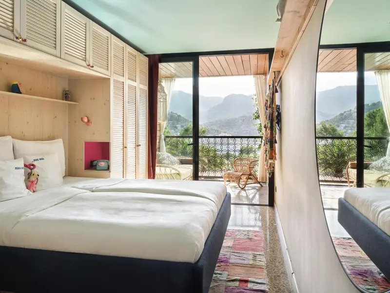 Une chambre lumineuse avec un lit et une vue sur un paysage montagneux.