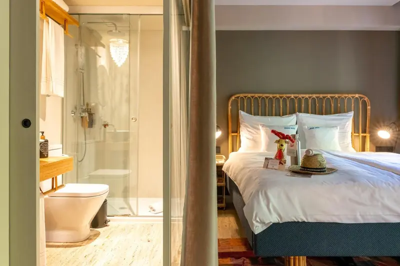 Une chambre lumineuse avec un lit et une salle de bain attenante.