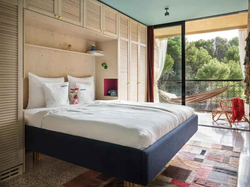 Une chambre lumineuse avec un grand lit et un accès à une terrasse.