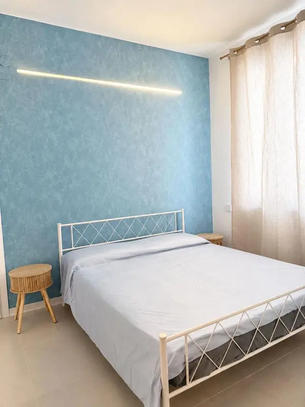Une chambre lumineuse avec un lit simple et des tables de chevet.