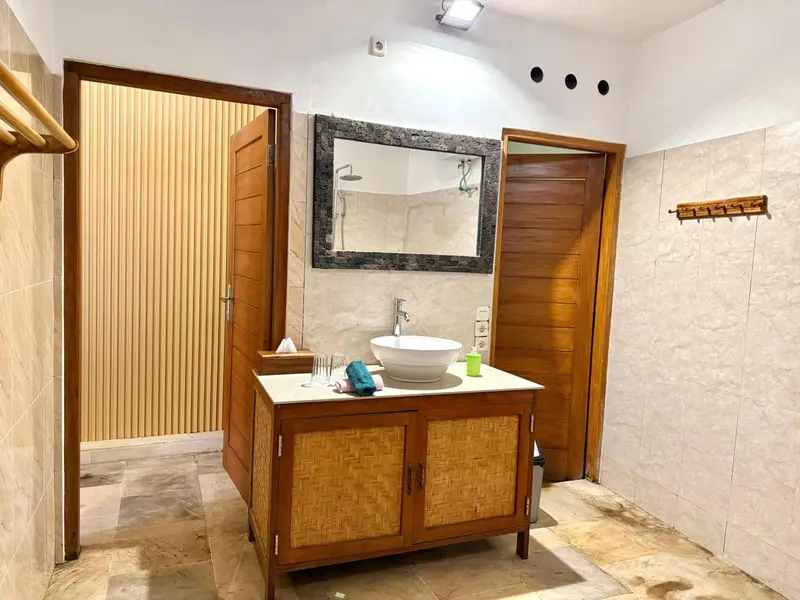 Une salle de bain lumineuse avec une douche à l'italienne et un meuble-lavabo en bois.