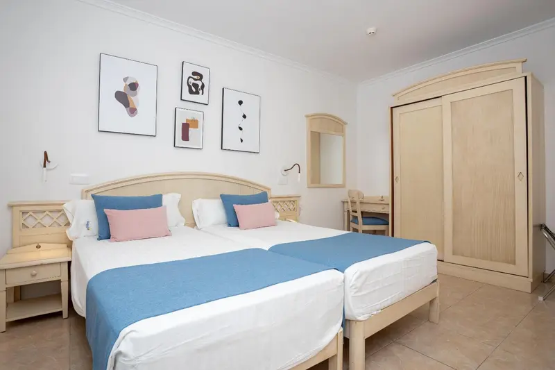 Une chambre lumineuse avec un grand lit et des meubles en bois.