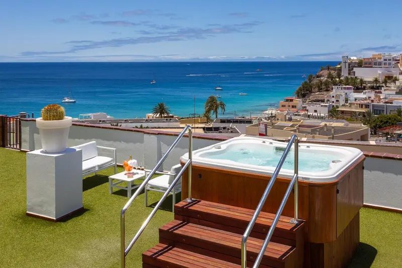 Terrasse avec jacuzzi et vue sur la mer et la ville.