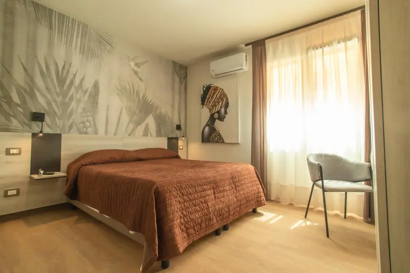 Une chambre à coucher lumineuse avec un grand lit et un décor mural.