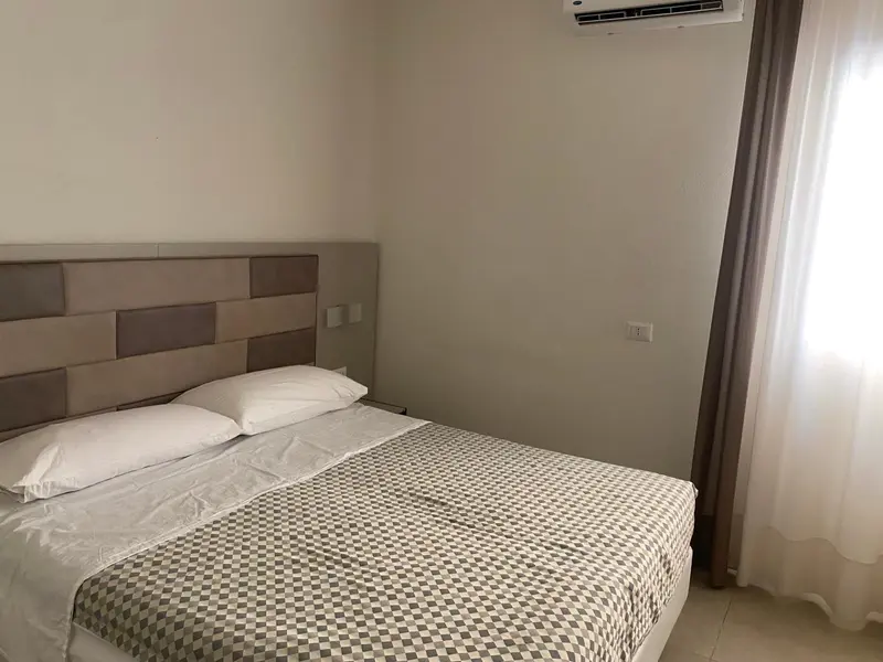 Une chambre avec un grand lit recouvert d'une courtepointe à motifs et des oreillers blancs.