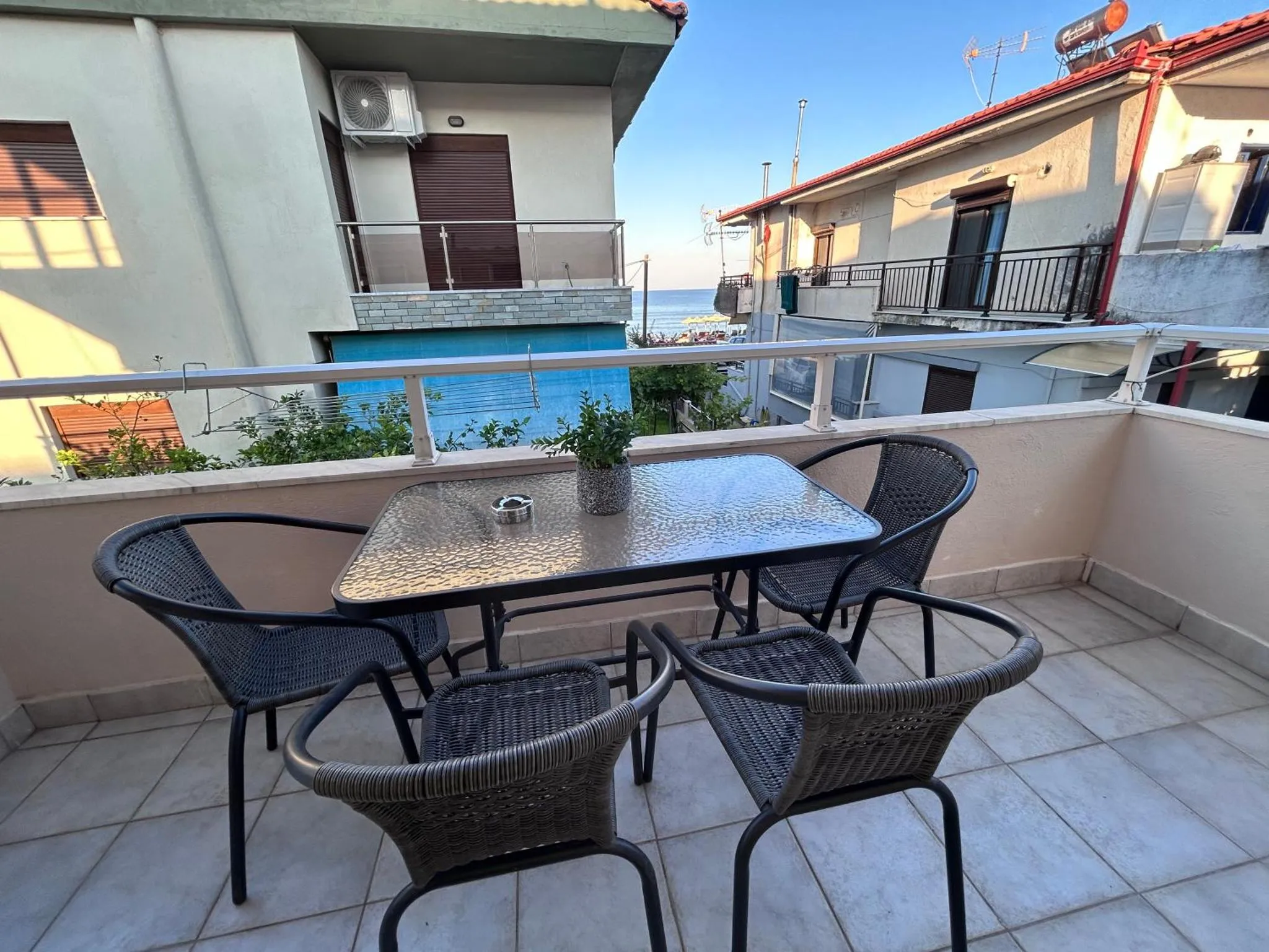 Terrasse avec mobilier de jardin et vue sur la mer.
