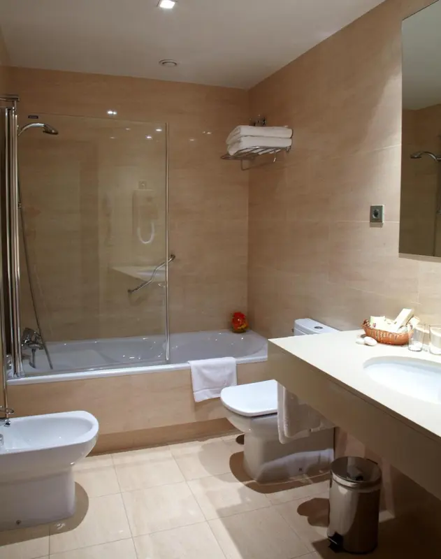 Une salle de bain lumineuse avec baignoire et douche.