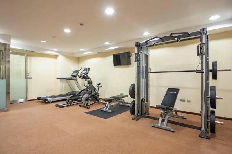 Une salle de sport lumineuse avec des équipements de musculation et cardio.