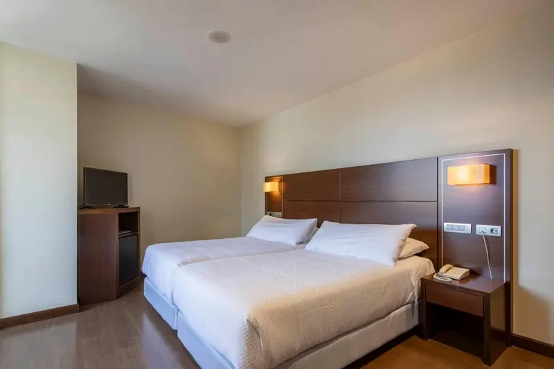 Une chambre d'hôtel avec un grand lit et une télévision.