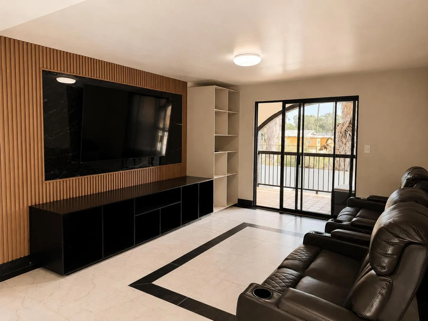 Espace de détente intérieur avec canapés et grand écran plat.