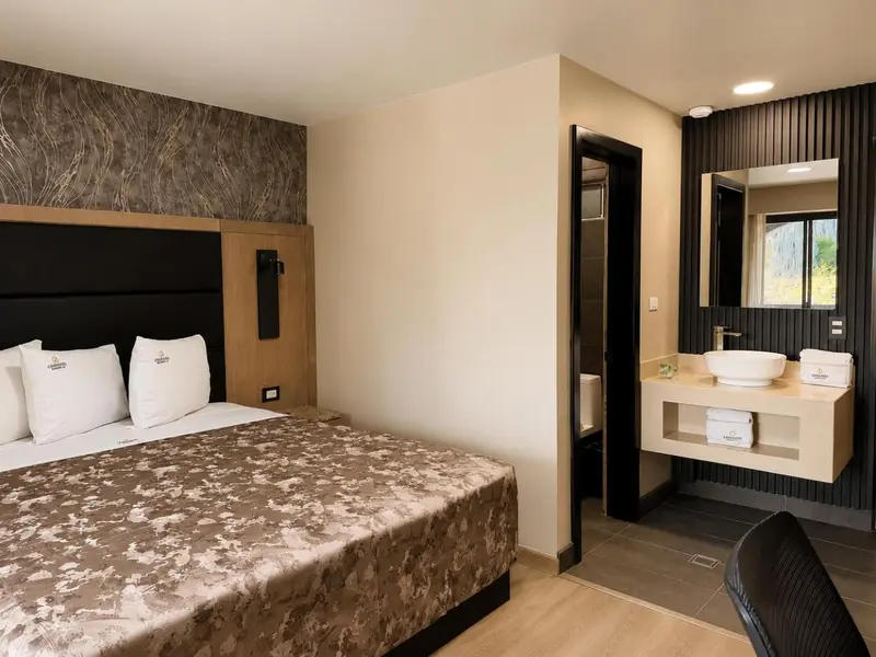 Une chambre d'hôtel moderne avec un grand lit et une salle de bain attenante.