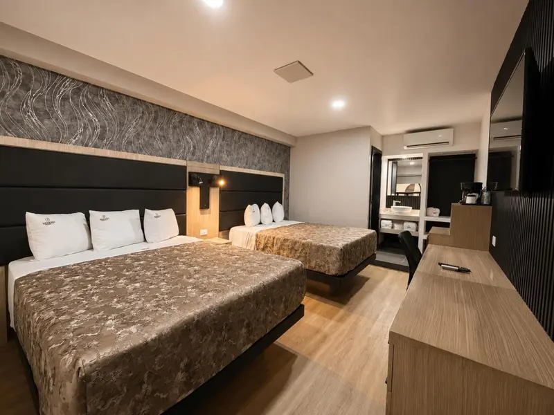 Une chambre d'hôtel moderne avec deux lits doubles et un bureau.