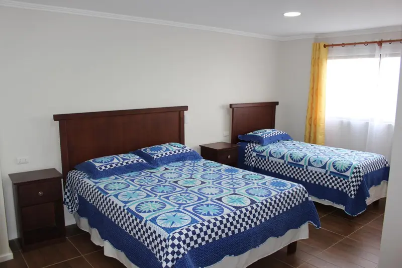 Une chambre avec deux lits simples et des tables de chevet.