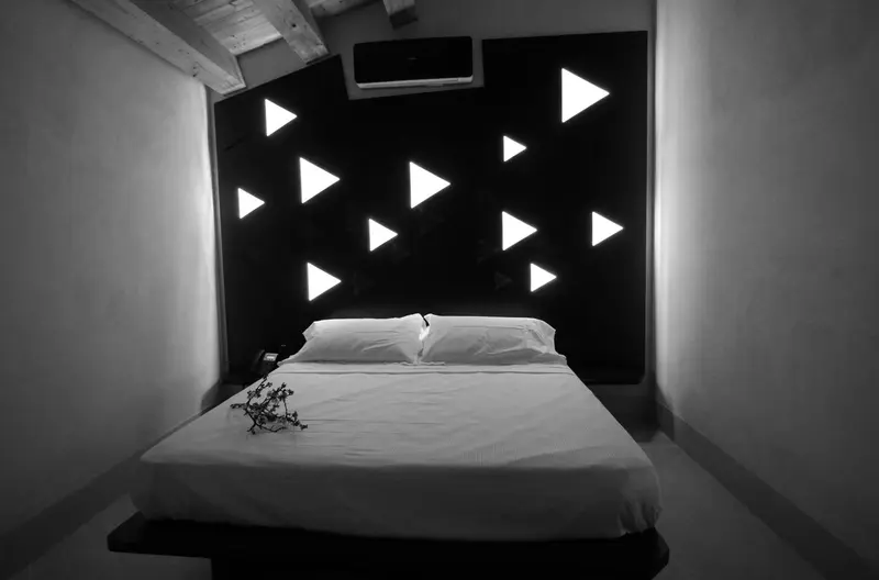 Une chambre lumineuse avec un grand lit et un mur décoratif.