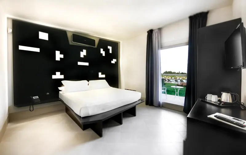 Une chambre moderne avec un lit blanc et une décoration graphique.