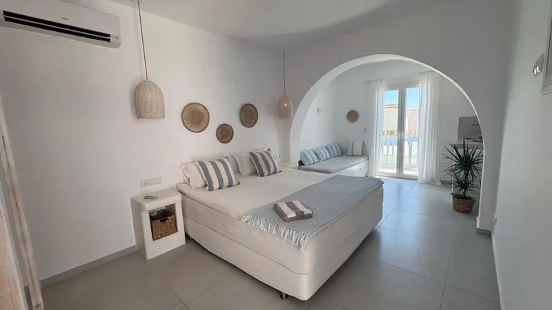 Une chambre lumineuse avec un lit double et un espace détente.