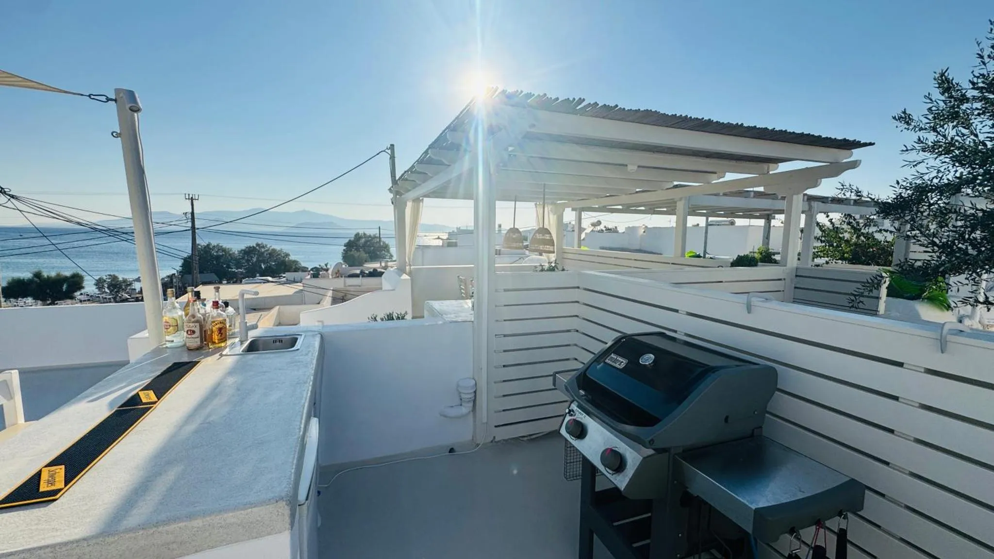 Terrasse avec comptoir et barbecue face à la mer.
