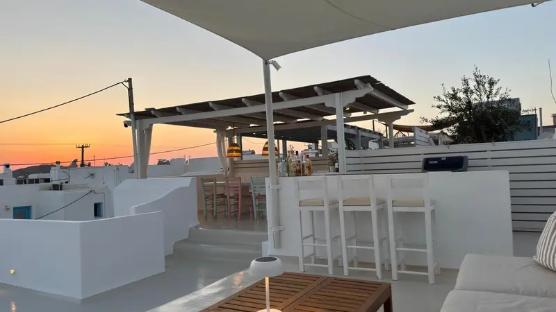 Terrasse ombragée avec bar et mobilier d'extérieur.