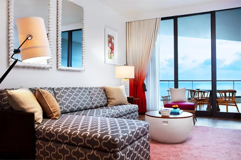 Un salon lumineux s'ouvre sur une terrasse avec vue sur la mer.