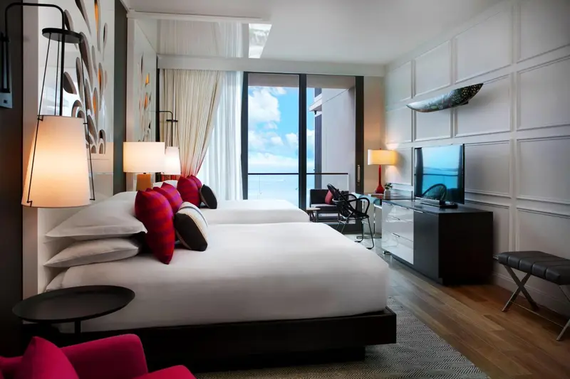 Une chambre lumineuse avec un grand lit et une vue sur la mer.