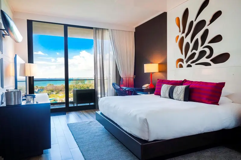 Une chambre lumineuse avec un grand lit et une vue sur la mer.