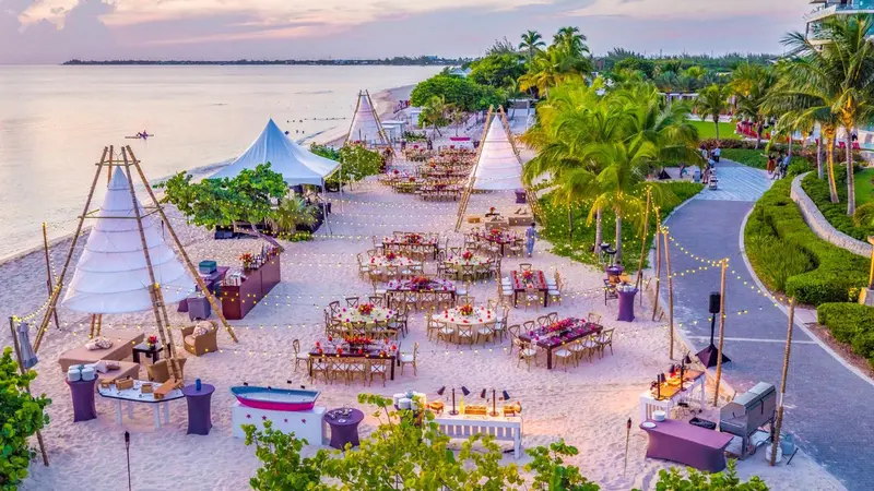 Tables dressées sur une plage au coucher du soleil.